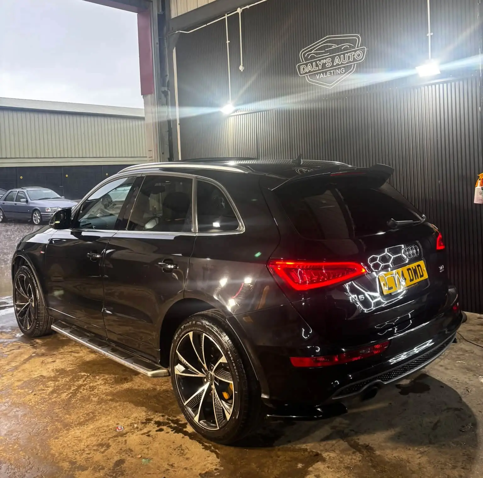 Black Audi Q5 from the rear, glossy after its winter protection package, under the Daly's Auto Valeting sign